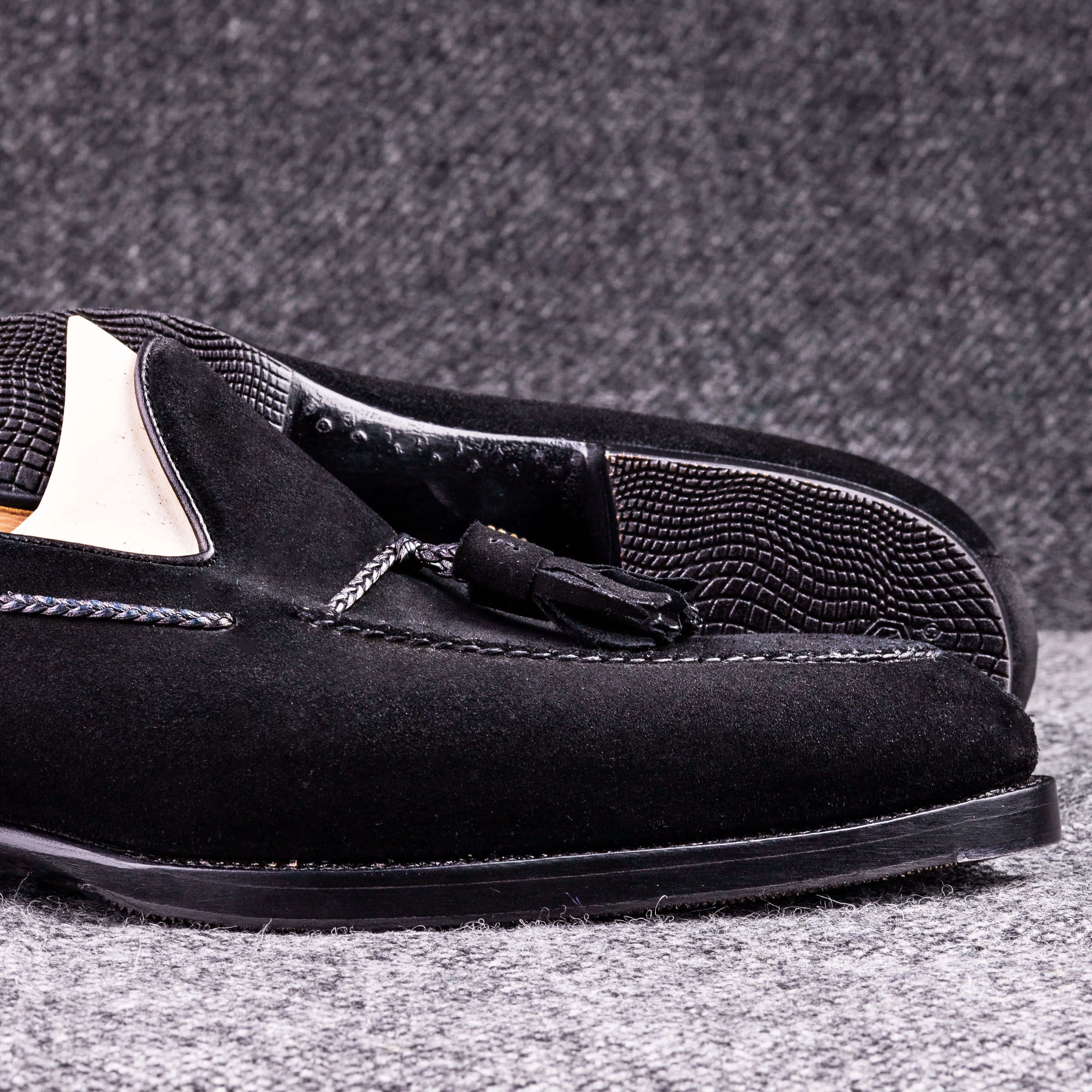 Tassel loafer with hand stitched apron in black suede